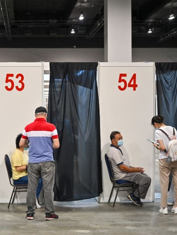 People wait to receive a dose of the Pfizer-BioNTech Covid-19 coronavirus vaccine during the first mega Covid-19 vaccination at the Malaysia International Trade and Exhibition Centre in Kuala Lumpur on May 31, 2021.

