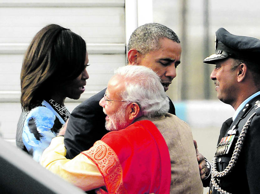 Indian Premier Narendra Modi and US President Barack Obama greeting each other with a hug as Mrs Michelle Obama looks on at Palam Air Force Station in New Delhi yesterday. Mr Obama is the first US leader to visit India twice during his presidency. Photo: AP