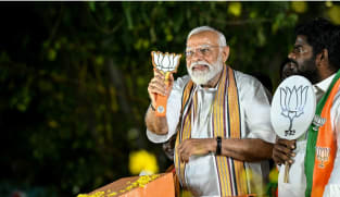 Mr Narendra Modi, India's Prime Minister and leader of the ruling Bharatiya Janata Party (BJP), holds the party symbol during a road show at an election campaign held ahead of the country's upcoming general elections, in Chennai on April 9, 2024.