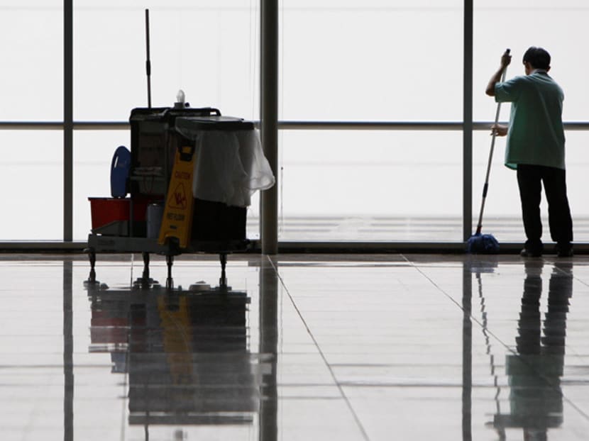 A cleaner mops the floor of an empty hall at a convention centre in Singapore.