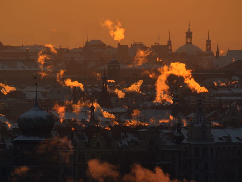 Smoke rises over the rooftops of central Prague as sun rises on Jan 11, 2017. The temperature dropped to -17°C in the Czech capital. Photo: AFP
