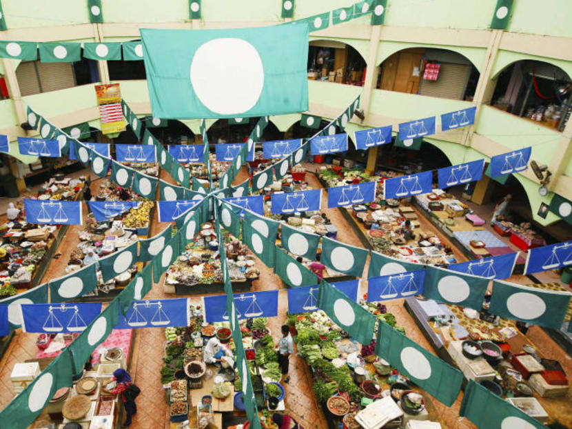 Flags of Malaysia's ruling Barisan Nasional (BN) coalition (blue) and opposition Parti Islam SeMalaysia (PAS) (green) on display at a market in Kota Baru, Kelantan. Analysts say PAS will struggle to defend Kelantan, which it has ruled since 1990, against both its former allies and rival BN Photo: Reuters