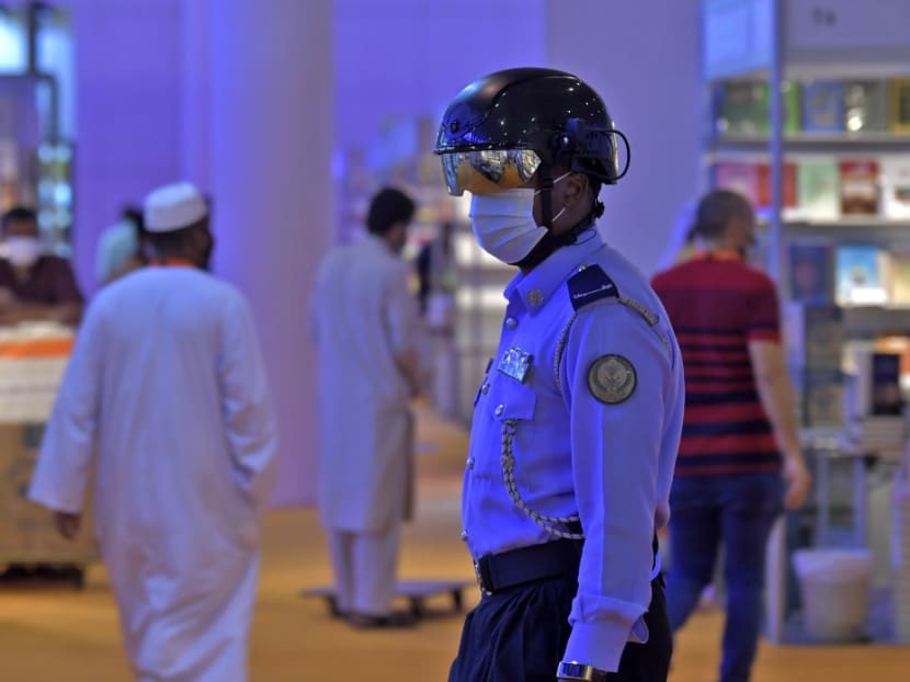 An Emirati policeman uses a smart helmet to detect people's temperature as a tool to fight the spread of the Covid-19 coronavirus among the visitors of the the Sharjah International Book Fair in Sharjah, northeast of Dubai.