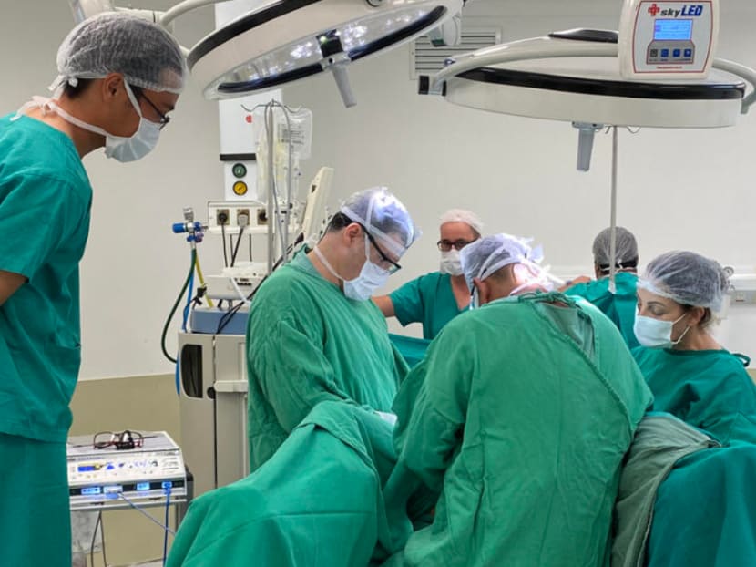 This handout picture released by the Transgender Centre Brazil shows the Brazilian doctor Jose Martins and his medical team from the Transgender Centre Brazil performing a sex reassignment surgery on the 19-year-old Brazilian twins Sofia Albuquerck and Mayla Rezende, in Blumenau, Brazil, on February 11, 2021.