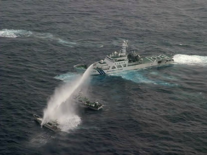 This handout photo taken on January 24, 2013 and released by the Japanese Coast Guard shows a Japan Coast Guard vessel (R) spraying water at a Taiwanese boat (bottom L) after the latter vessel ventured near the disputed Senkaku islands, known as the Diaoyu in Chinese, in the East China Sea. Photo: AFP