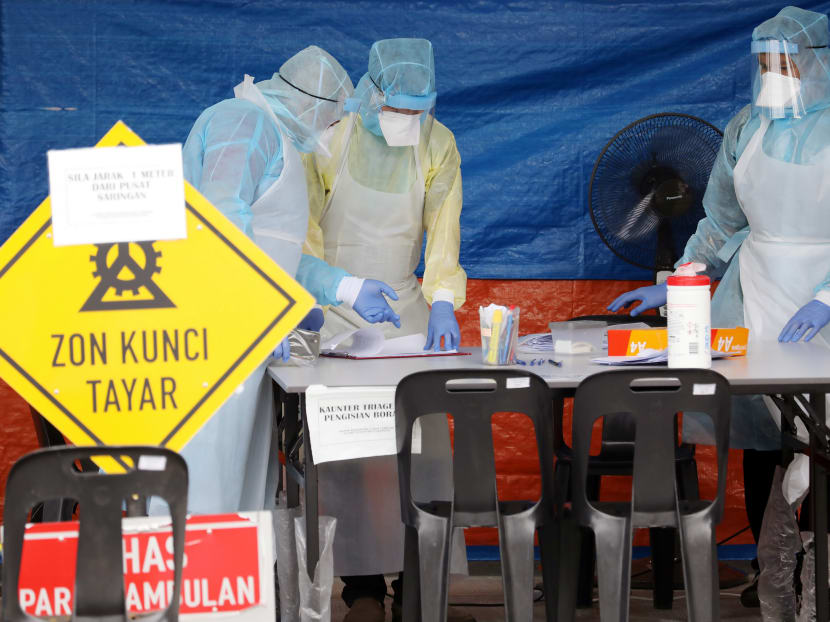 Health workers in protective suits work in a tent erected to test for Covid-19 at a clinic in Kuala Lumpur, Malaysia, on March 23, 2020.