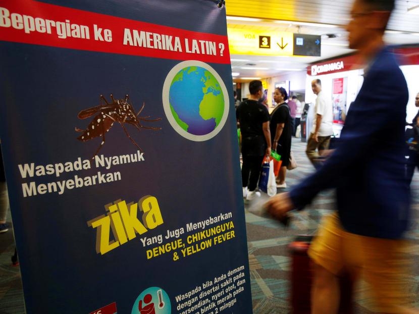 Passengers arriving from Singapore walk near a banner about Zika virus at the Soekarno-Hatta airport in Jakarta, Indonesia, on Aug 30, 2016. Photo: Reuters