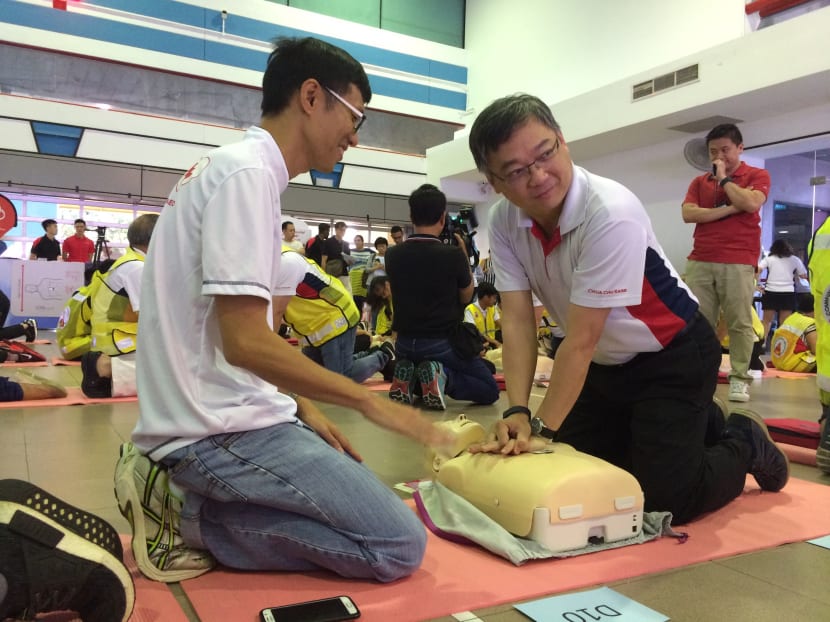 Health Minister and MP for Chua Chu Kang GRC Gan Kim Yong practising cardiopulmonary resuscitation using the CPRcard, a device that gauges quality of chest compressions, at the Chua Chu Kang Health and Sports Carnival. 200 residents received the CPRcard yesterday after training. Photo by Neo Chai Chin