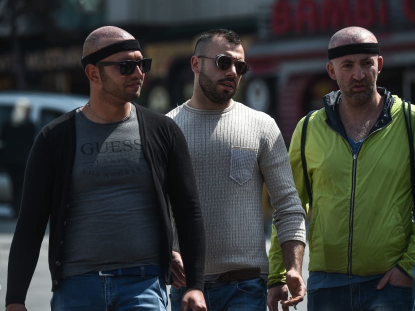 Patients walking on Taksim square after an hair transplant surgery on May 2, 2017 in Istanbul. Photo: AFP
