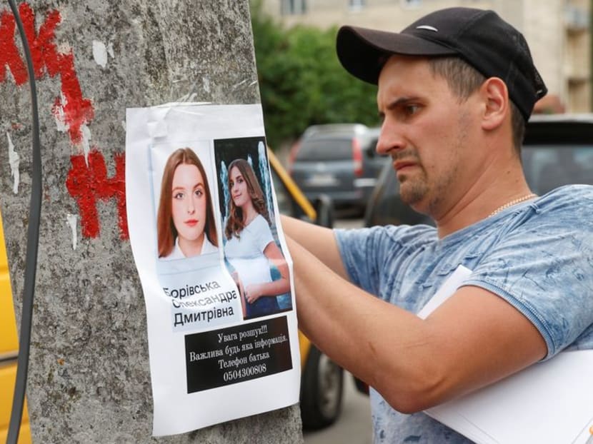 FILE PHOTO: A man place a poster advertisement about a missing person, at site of a Russian missile strike, as Russia's attack on Ukraine continues, in Vinnytsia, Ukraine July 15, 2022.  REUTERS/Valentyn Ogirenko