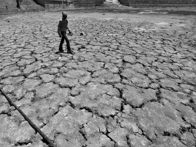 A man walking across a dried-up lake on a hot summer day in India. Due to global warming, July 2016 was the hottest ‘of all 1,639 months on record’, since 1880. Photo: REUTERS