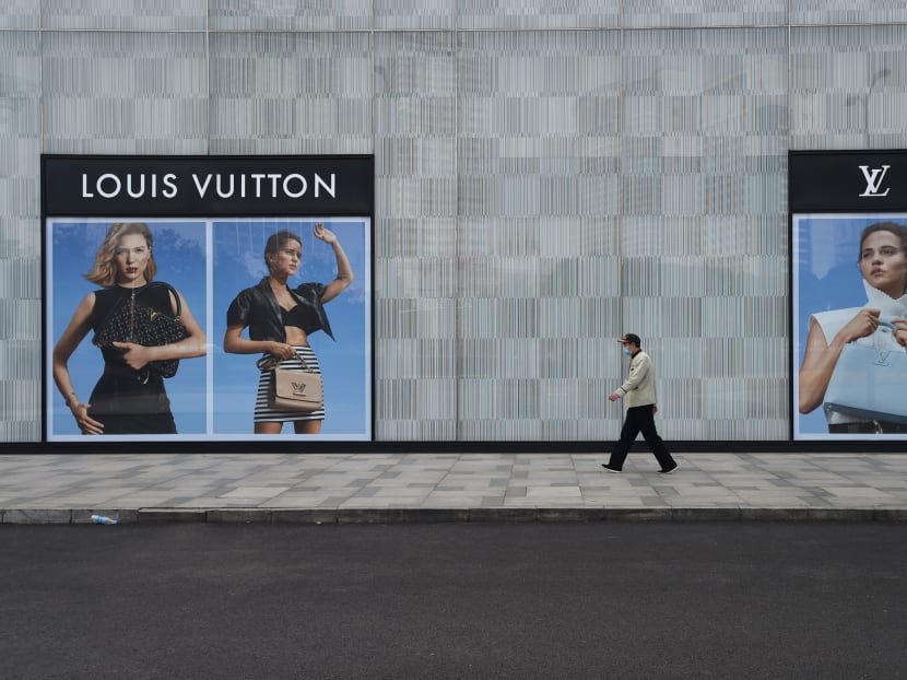 A man wearing a face mask walks past a store of French luxury brand Louis Vuitton at a shopping mall in Wuhan, the epicentre of the novel coronavirus outbreak, Hubei province, China on Feb 25, 2020. A man wearing a face mask walks past a store of French luxury brand Louis Vuitton at a shopping mall in Wuhan, the epicentre of the novel coronavirus outbreak, Hubei province, China on Feb 25, 2020.