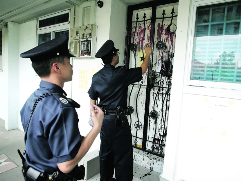Police officers checking on a flat targeted by loansharks. TODAY file photo