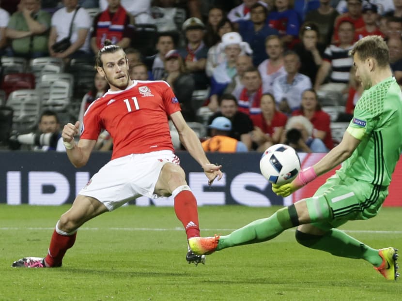 Wales' Gareth Bale, left, scores his side's third goal past Russia goalkeeper Igor Akinfeev during the Euro 2016 Group B soccer match between Russia and Wales at the Stadium municipal in Toulouse, France, Monday, June 20, 2016. Photo: AP