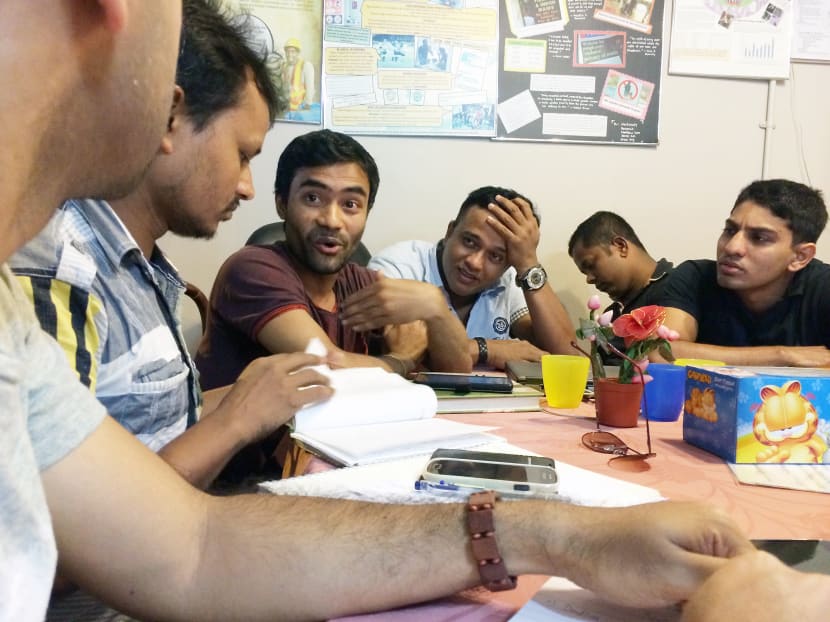 Bangladeshi shipyard worker Rajib Shil Jibon (in maroon t-shirt) reading one of his poems to fellow poetry enthusiasts at Dibashram, a drop-in centre for migrant workers in Little India. TODAY file photo