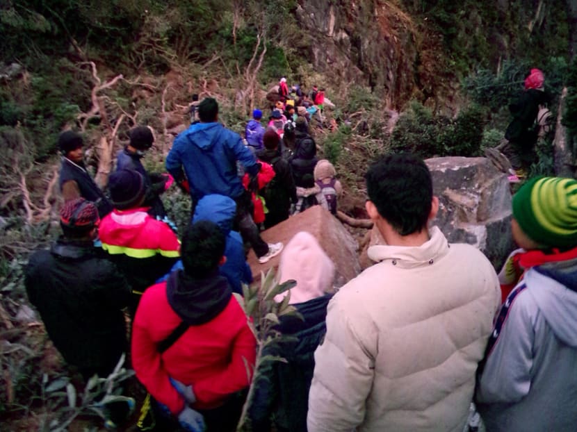 Climbers make their way down the Timpohan Trail with the help of local guides after Friday’s earthquake. Photo: AP