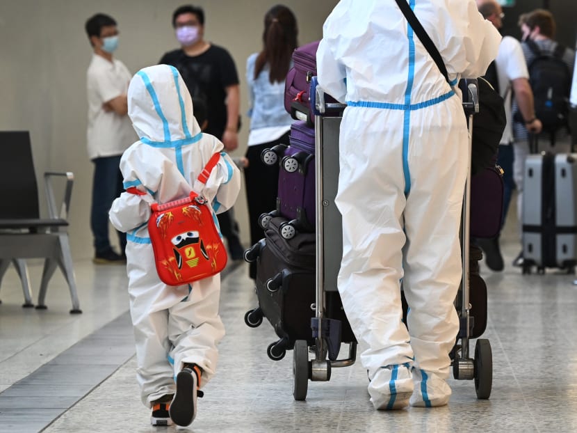 International travellers wearing personal protective equipment arrive at Melbourne's Tullamarine Airport on Nov 29, 2021 as Australia records its first cases of the Omicron Covid-19 variant.