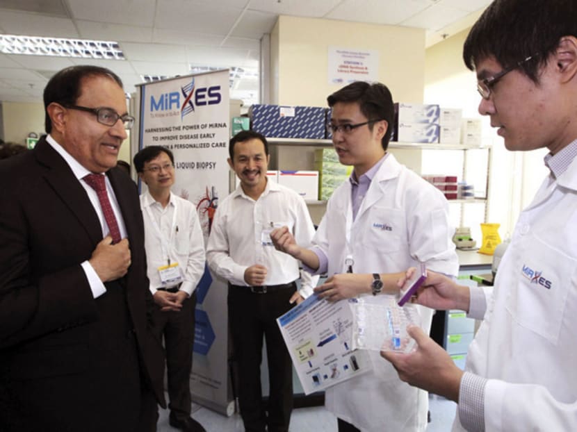 Mr Iswaran being briefed on the ONCO-MiR DX gastric test — a blood-based, non-invasive test to diagnose gastric cancer — during his tour of the Diagnostics Development (DxD) Hub. Photo: Ooi Boon Keong