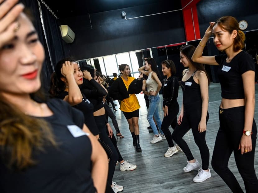 This photograph taken on March 2, 2021 shows instructor Pham Kieu Ly (centre) demonstrating a pose to participants during a course teaching them how to pose for photographs on their mobile phones at a studio in Hanoi. This photograph taken on March 2, 2021 shows instructor Pham Kieu Ly (centre) demonstrating a pose to participants during a course teaching them how to pose for photographs on their mobile phones at a studio in Hanoi.
