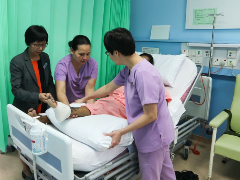 Ms Susie Goh (far left), executive director of St Luke's Community Wound Centre and St Luke's Academy, instructing nurses on how to place a pillow under a patient's ankle, which is prone to developing bedsores.