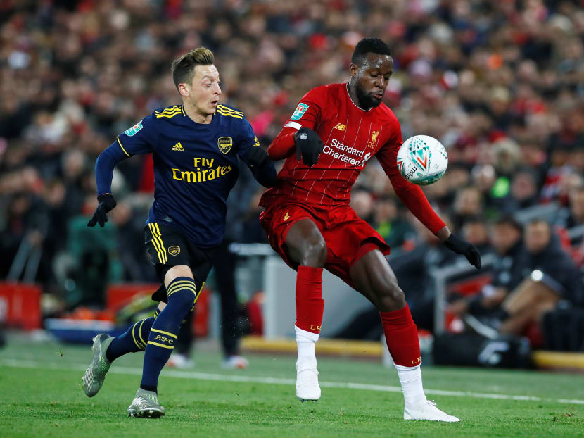 Arsenal's Mesut Ozil (left) in action with Liverpool's Divock Origi in a Carabao Cup fourth-round match at Anfield, Liverpool on Oct 30, 2019.