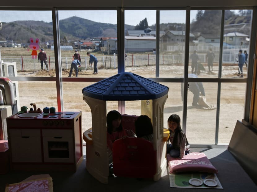 Children play inside a playroom as the tsunami-crippled Fukushima Daiichi nuclear power plant operator Tokyo Electric Power Co volunteers removed ice and snow and levelled dirt in their playground, at a Miyakoji child care center at Miyakoji area in Tamura, Fukushima prefecture, April 1, 2014. Photo: Reuters