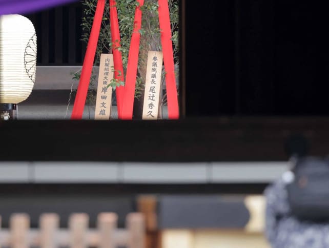 A wooden plaque showing the name of Japan's Prime Minister Fumio Kishida is seen with a "masakaki" tree (L) that he sent as an offering to the Yasukuni Shrine on the spring festival in Tokyo on April 21, 2024.