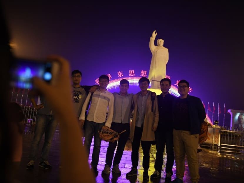 Visitors posing for photos in front of the statue of late Chinese communist leader Mao Zedong in the main “East is Red Square” of Nanjie village, in China’s central Henan province. Every year, hundreds of thousands of visitors flock to the hamlet in central Henan province which has become an attraction with its idealised vision of village life right out of the Communist past. Photo: AFP