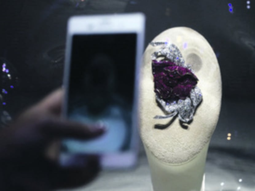 Invited guests viewing and taking photos of a clip shaped in the form of a Peony during a press conference to announce the upcoming Van Cleef & Arpels: The Art and Science of Gems exhibition at the ArtScience Museum. Photo: Don Wong