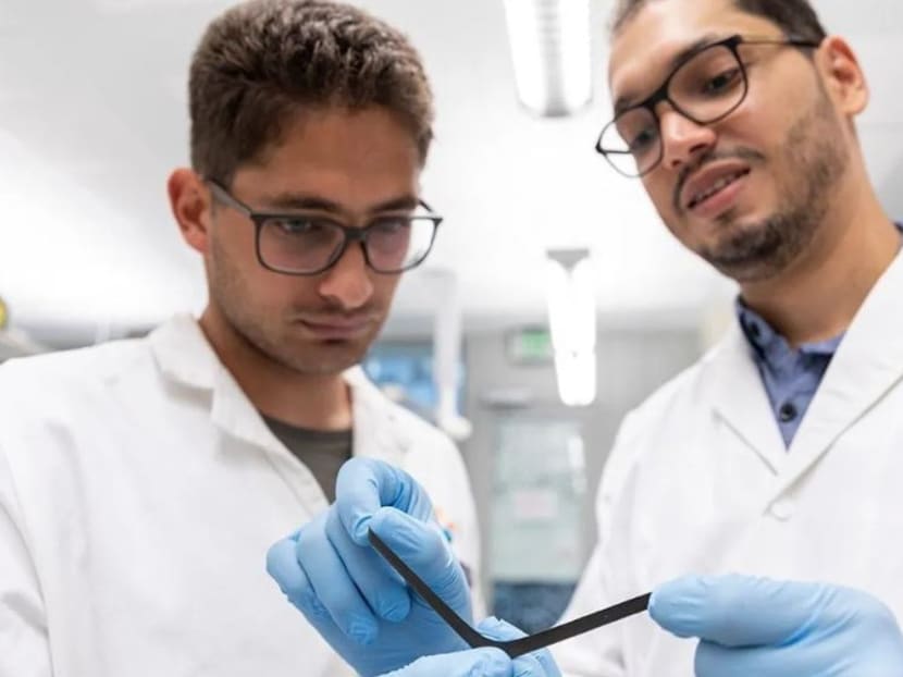 PhD students Liam Swanepole (left) and Abdullah Almansouri with the electronic skin.