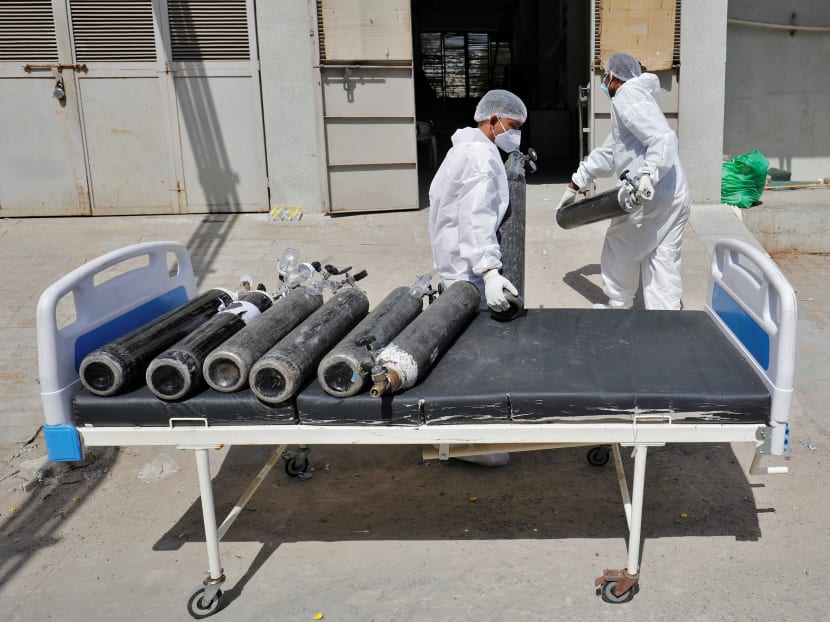 Workers use a bed to transport empty oxygen cylinders to a filling station at a COVID-19 hospital, amidst the spread of Covid-19 in Ahmedabad, India, April 19, 2021.