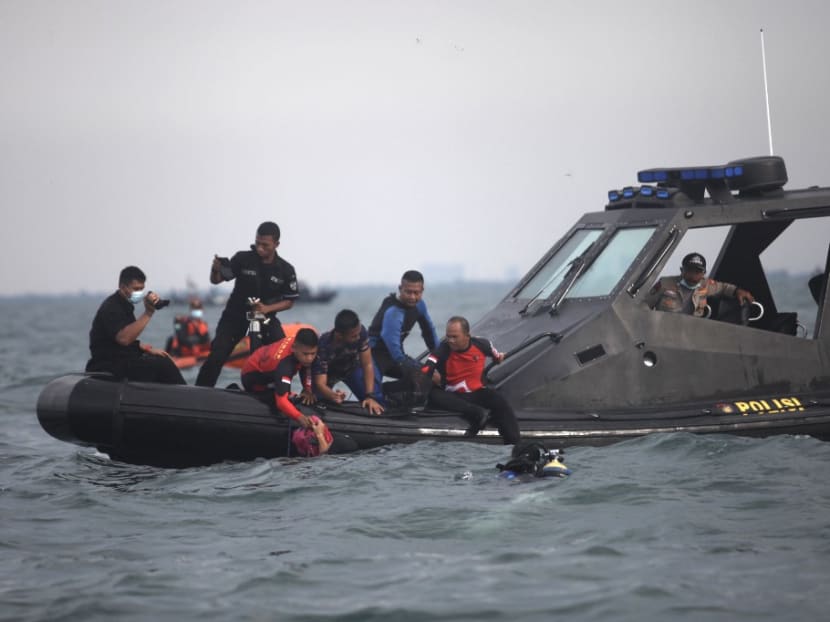 Divers bringing up bags filled with debris and body parts to a search and rescue boat from Sriwijaya Air flight SJ182 at Tanjung Priok port, north of Jakarta, on Jan 11, 2021, which were recovered during search operations off the coast for the Boeing 737-500 which crashed into the Java Sea minutes after takeoff on Jan 9.