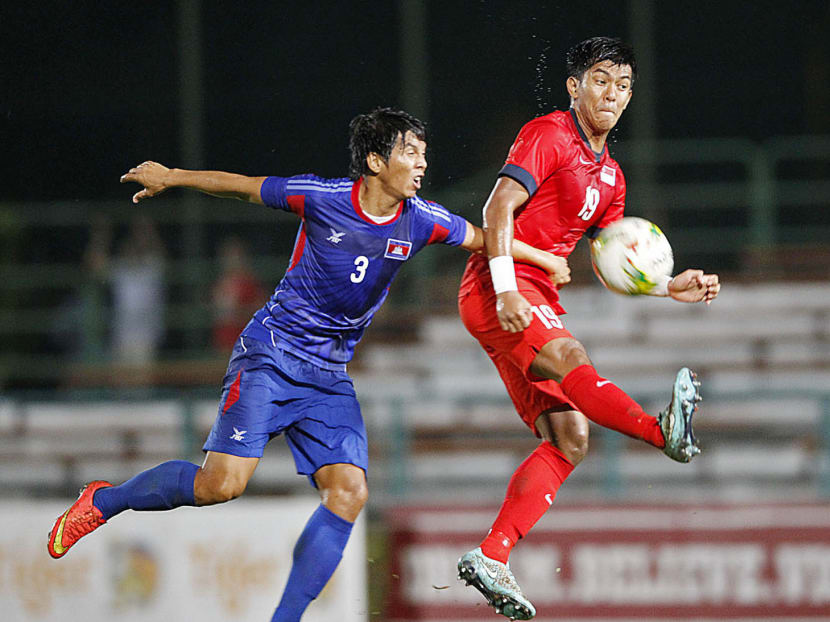 Khairul Amri (right) fighting for the ball with Hong Pheng of Cambodia. Amri was among Singapore’s goalscorers, who also included Faris Ramli, Shahril Ishak and Safuwan Baharudin. PHOTO: WEE TECK HIAN