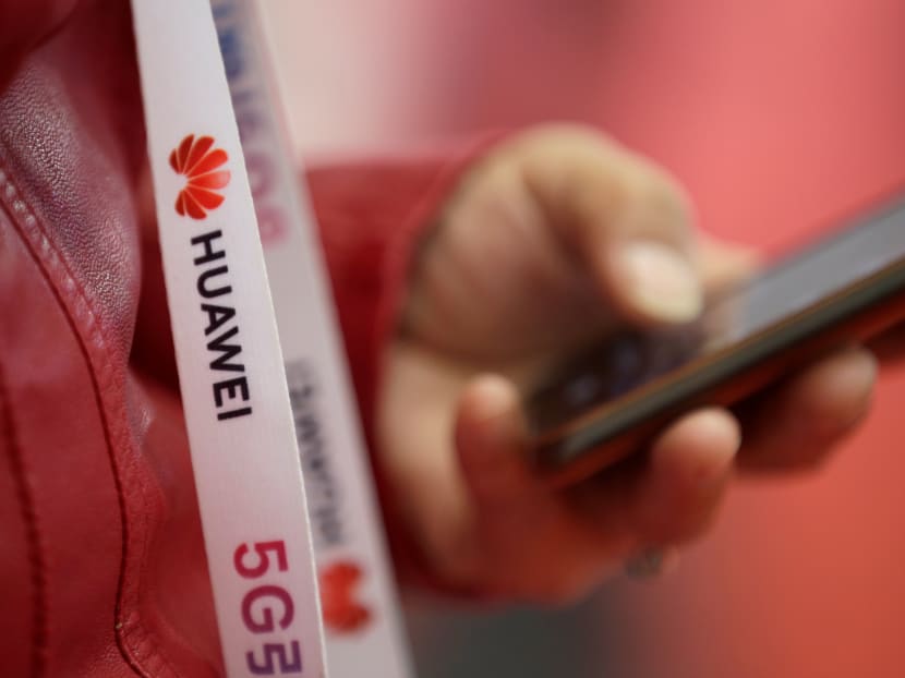 An attendee wears a badge strip with the logo of Huawei and a sign for 5G at the World 5G Exhibition in Beijing, China, Nov 22, 2019.