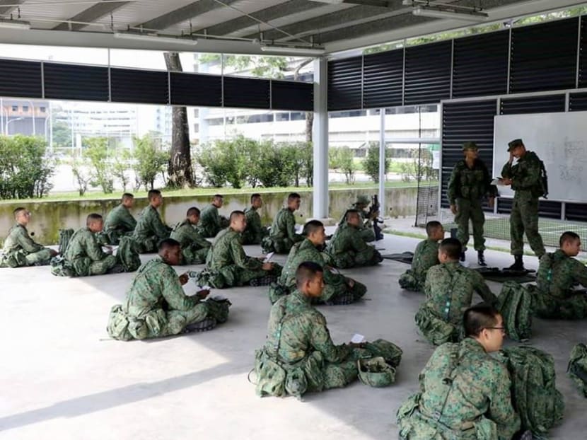 Soldiers of The Singapore Army practising safe distancing while going through a briefing at the training shed.