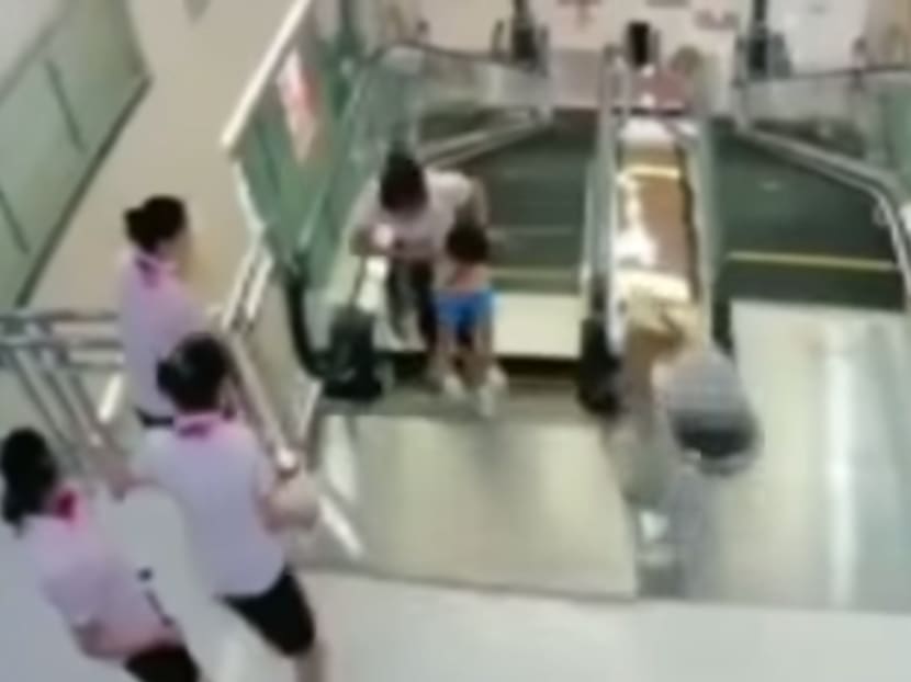 Screengrab from the CCTV camera which captured the scene of the woman who got trapped in an escalator after pushing her son to safety. Photo: YouTube/Mazzy Shazzy AR1