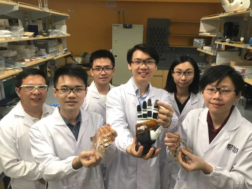 Assistant Professor Benjamin Tee (third from right) and some members of his National University of Singapore team, who have developed sensitive electronic skin that could be in commercial use in machines within two years.