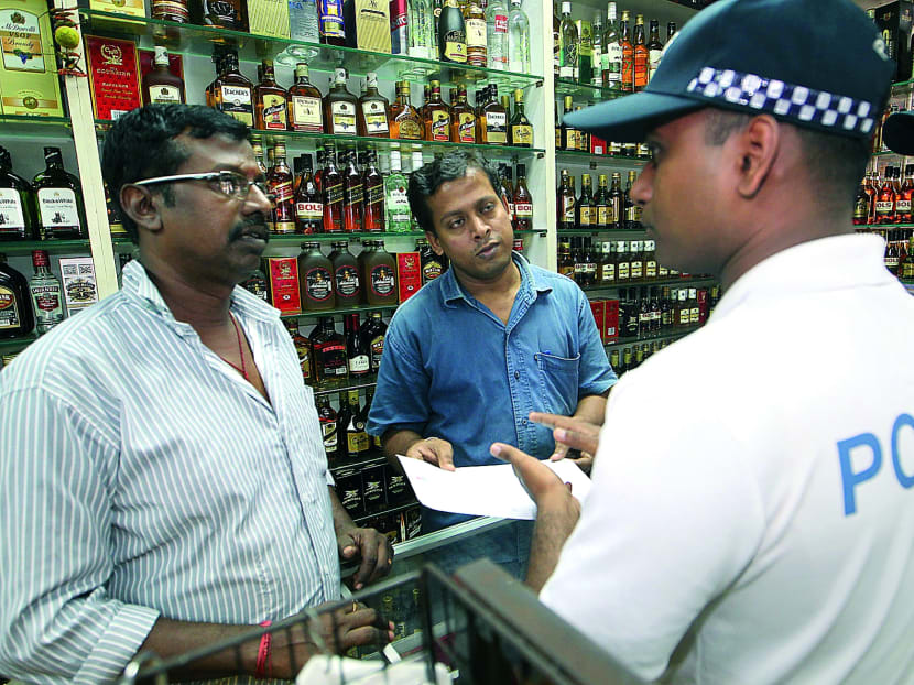 Police personnel handed out notifications on the suspension of liquor licences at Little India on selected dates and times on Dec 19, 2013. Photo: Ooi Boon Keong