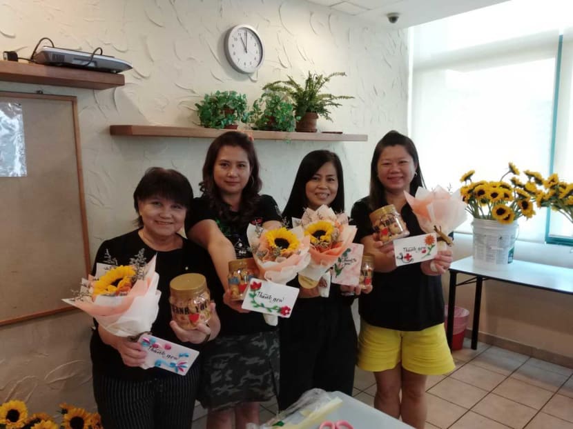 (From left)  Ms Ong Ai Peng, Ms Susan Heng, Ms Veronica Ong and Ms Jasling Boo with the cookies and flowers they prepared for healthcare workers and cleaners.