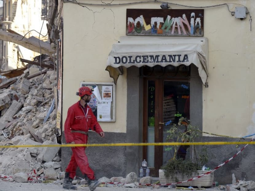 A rescue worker walks past rubble and debris of a destroyed ice cream shop in the damaged central Italian village of Amatrice on August 26, 2016, three days after a 6.2-magnitude earthquake struck the region killing some 281 people. Photo: AFP
