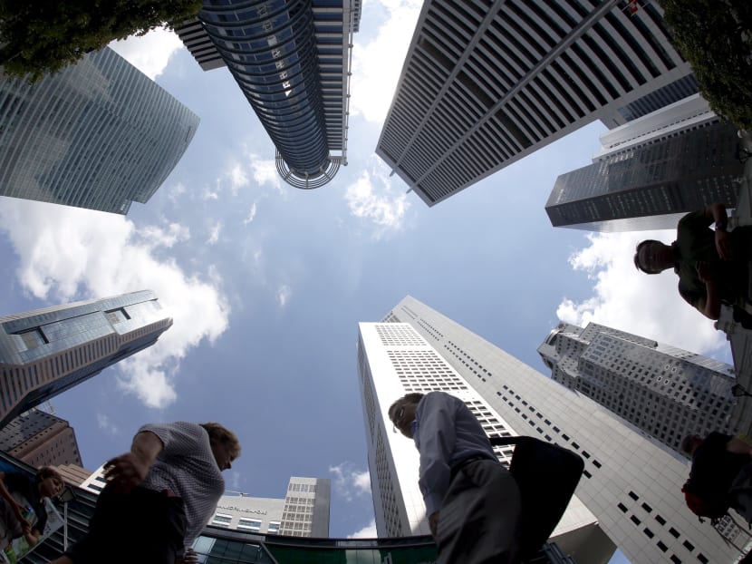 People walk past office buildings at the central business district in Singapore in this April 14, 2015 file photo. Photo: Reuters