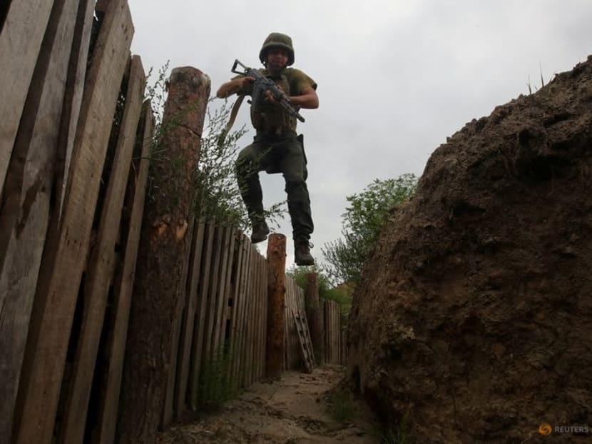 FILE PHOTO: A member of the Ukrainian National Guard jumps into a trench at a position near a front line, as Russia's attack on Ukraine continues, in Kharkiv region, Ukraine August 3, 2022. REUTERS/Vyacheslav Madiyevskyy/File Photo