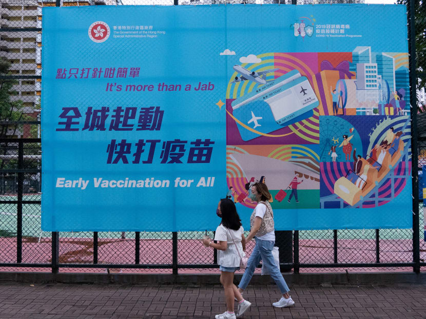 People walk past a government banner encouraging the public to take the Covid-19 vaccine in Hong Kong on Aug 15, 2021. People walk past a government banner encouraging the public to take the Covid-19 vaccine in Hong Kong on Aug 15, 2021.