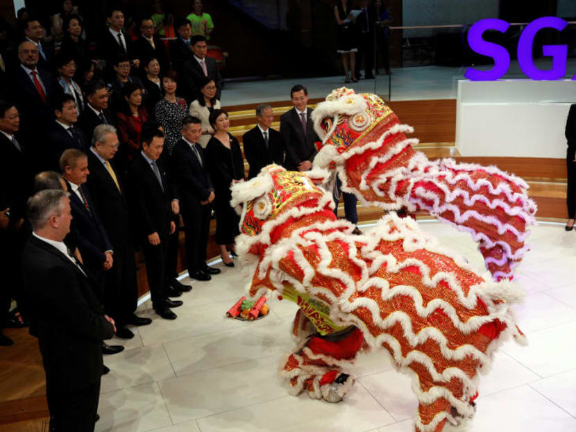 Chua Sock Koong, CEO of Singtel, Loh Boon Chye, CEO of Singapore Exchange, Tong Yew Heng, CEO of NetLink NBN Trust and Chaly Mah, Chairman of Netlink NBN Trust watch a lion dance performance during the listing ceremony of NetLink NBN Trust in the Singapore Stock Exchange July 19, 2017. Photo: Reuters
