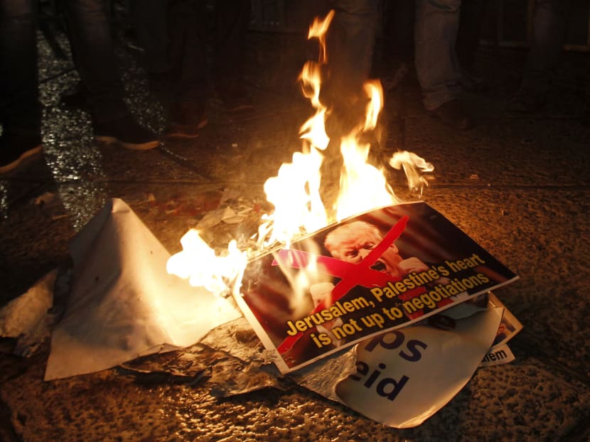 Palestinian demonstrators burn posters of the US president in Bethlehem's Manger Square in protest to him declaring Jerusalem as Israel's capital on December 6, 2017. Photo: AFP