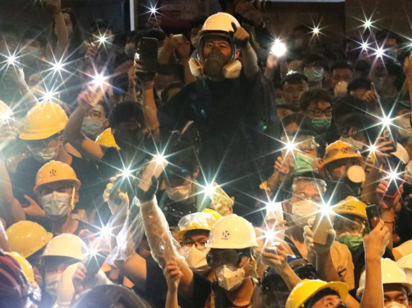 Protesters raise up their mobile flashlights outside police headquarters in Wan Chai, Hong Kong. Protesters raise up their mobile flashlights outside police headquarters in Wan Chai, Hong Kong.