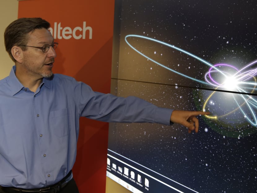 Caltech astronomer Michael Brown points to a yellow dot simulating Planet 9 on a computer video simulation. Photo: AP