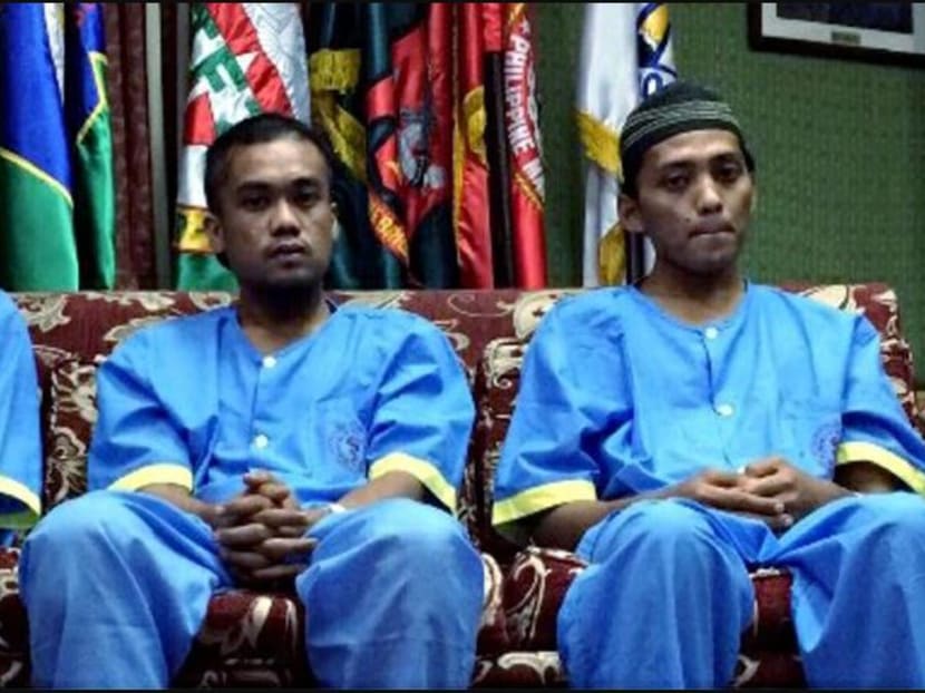 (From left) Fandy Bakran, 26, Mohammad Jumadil Rahim, 23, and Mohd Ridzuan Ismail, 32, were presented to the local media in Zamboanga City, Philippines after receiving treatment at a military hospital in Jolo. Photo: Inquirerdotnet’s Twitter