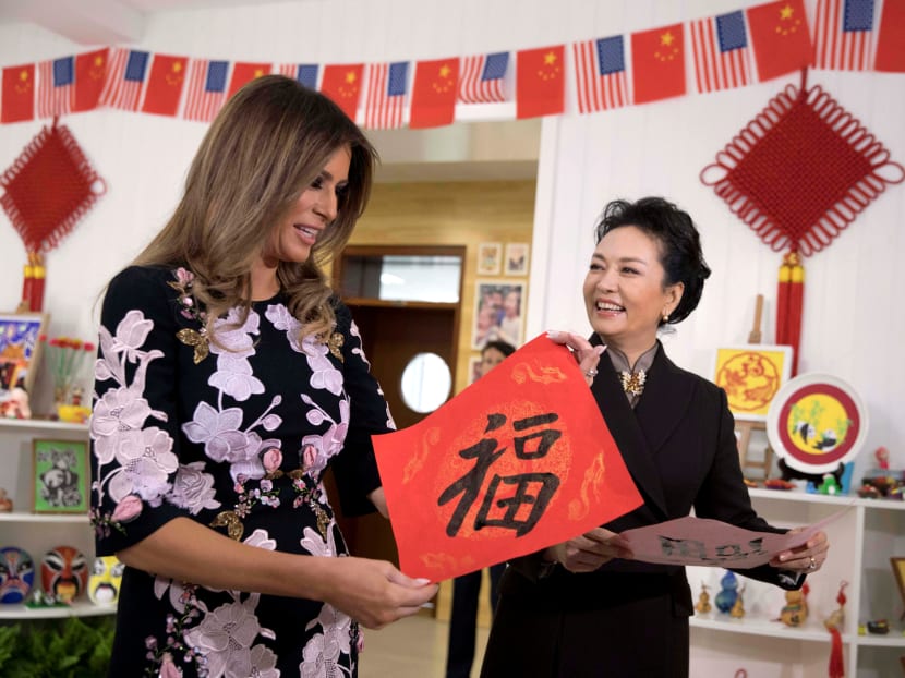 Photo of the day: Chinese first lady Peng Liyuan looks at US first lady Melania Trump as she holds up a Chinese calligraphy of the character for "Fortune" written by a student during a visit to the Banchang Primary School in Beijing, China. Photo: Reuters