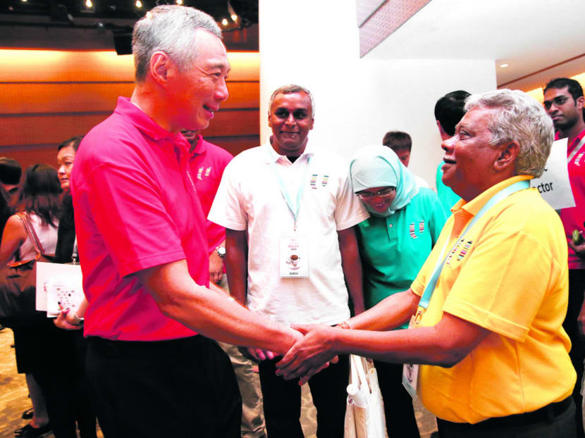 PM Lee with union leader G Muthukumarasamy during the May Day Rally yesterday. PM Lee said he felt proud Mr Muthukumarasamy could stand equal to former leaders to share stories of the late Mr Lee. Photo: Don Wong